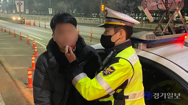 경찰의 단속을 피해 역주행을 시도하다 붙잡힌 운전자가 음주 측정기기로 음주 측정을 하고 있다. 김정규기자