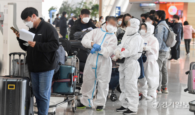 15일 오전 인천국제공항 제1여객터미널 출국장에서 방역복 차림의 여행객들이 출국 수속을 밟고 있다. 정부는 오는 21일부터 시행할 백신 접종완료 입국자에 대한 자가격리 면제 방침을, 이전 입국자에 대해서도 소급 적용할 계획이다. 장용준기자