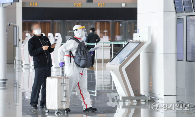 15일 오전 인천국제공항 제1여객터미널 출국장에서 방역복 차림의 여행객들이 출국 수속을 밟고 있다. 정부는 오는 21일부터 시행할 백신 접종완료 입국자에 대한 자가격리 면제 방침을, 이전 입국자에 대해서도 소급 적용할 계획이다. 장용준기자