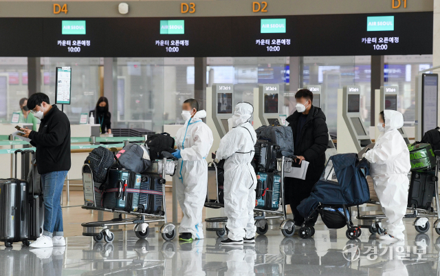 15일 오전 인천국제공항 제1여객터미널 출국장에서 방역복 차림의 여행객들이 출국 수속을 밟고 있다. 정부는 오는 21일부터 시행할 백신 접종완료 입국자에 대한 자가격리 면제 방침을, 이전 입국자에 대해서도 소급 적용할 계획이다. 장용준기자