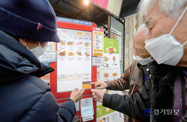 스마트폰, 키오스크 등 디지털기기가 일상화 되면서 디지털문화에 익숙하지 않은 노인들이 어려움을 겪고 있다. 사진은 수원특례시 한 패스트푸드점에서 키오스크로 음식을 주문하는 노인들. 윤원규기자