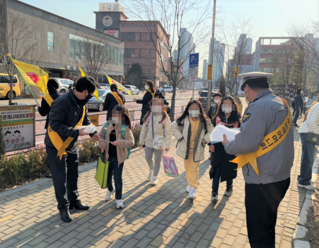 수원서부경찰서 관계자들이 지난 22일 금호초등학교 어린이 보호구역에서 녹색어머니회, 모범운전자회, 교사 등 유관기관 합동 교통안전 캠페인을 실시하고 있다. 수원서부경찰서 제공