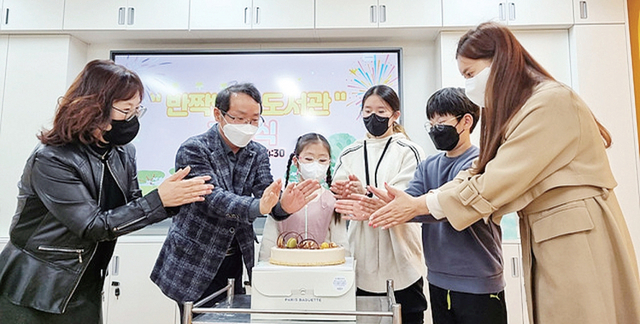 하남 산곡초 학생과 교사들이 도서관 개관식 행사에서 케이크를 자르고 있다.  산곡초 제공