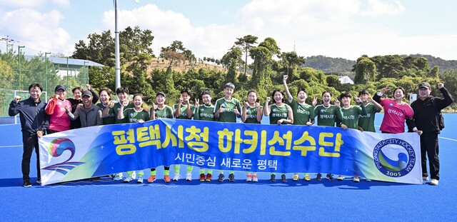 제104회 전국체전 하키 여자 일반부서 3년 만에 정상을 되찾은 평택시청 선수단의 한진수 감독(왼쪽)과 선수들이 기념촬영을 하며 즐거워 하고 있다.홍기웅기자
