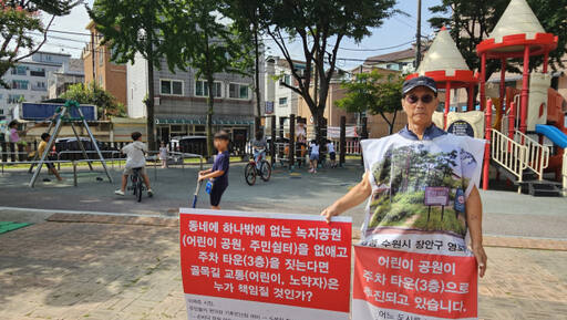 지난 8월16일 오전 9시께 수원특례시 장안구 영화어린이공원에서 주민대표 정종석씨가 주차장 건립 반대 안내문을 들고 있다. 오민주기자