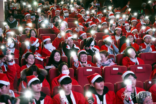 19일 오후 수원특례시청에서 열린 '제12회 수원 사랑의 산타' 행사에서 300여 명의 산타 자원봉사자 등이 휴대폰 불빛을 비추고 있다. 김시범기자