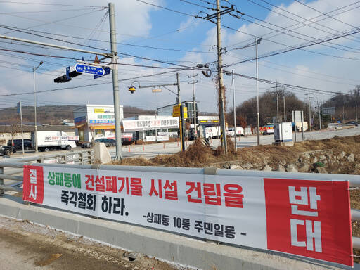 동두천시 상패동 입구에 건설폐기물 중간처리업체의 대규모 확장 이전에 반대하는 문구가 적힌 현수막이 걸려 있다. 송진의기자