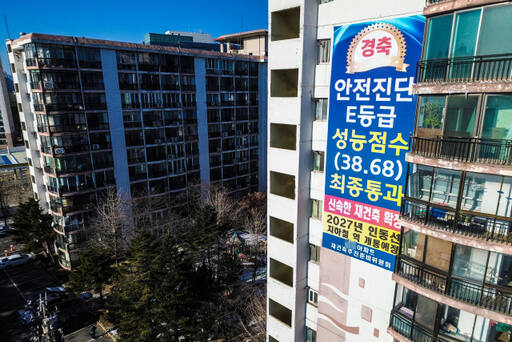 윤석열 대통령이 21일 재개발·재건축 착수 기준을 '위험성'에서 '노후성'으로 바꾸겠다는 입장을 밝힌 가운데 향후 법적·제도적 개선 방향이 주목되고 있다. 21일 오후 수원특례시 한 아파트 외벽에 ‘안전 진단 E등급을 받아 신속한 재건축이 확정됐다’는 내용의 ‘경축’ 현수막이 걸려 있다. 시설물안전관리특별법에서는 건축물 안전 등급을 A∼E 5개 등급으로 나누는데 D·E등급을 받은 건물은 붕괴 위험이 큰 재난 위험 시설로 분류한다.조주현기자