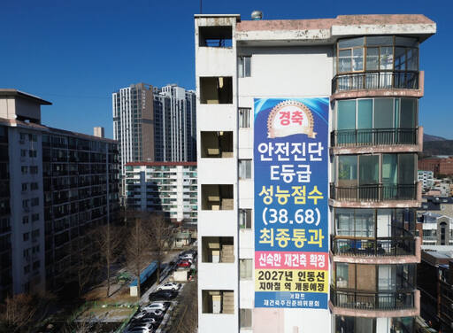 윤석열 대통령이 21일 재개발·재건축 착수 기준을 '위험성'에서 '노후성'으로 바꾸겠다는 입장을 밝힌 가운데 향후 법적·제도적 개선 방향이 주목되고 있다. 21일 오후 수원특례시 한 아파트 외벽에 ‘안전 진단 E등급을 받아 신속한 재건축이 확정됐다’는 내용의 ‘경축’ 현수막이 걸려 있다. 시설물안전관리특별법에서는 건축물 안전 등급을 A∼E 5개 등급으로 나누는데 D·E등급을 받은 건물은 붕괴 위험이 큰 재난 위험 시설로 분류한다.조주현기자