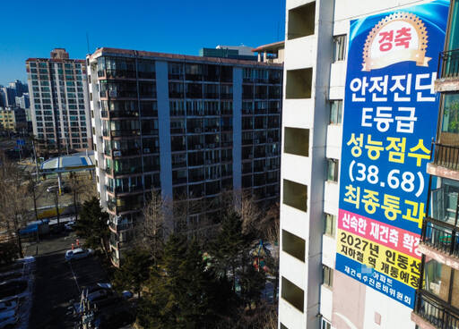윤석열 대통령이 21일 재개발·재건축 착수 기준을 '위험성'에서 '노후성'으로 바꾸겠다는 입장을 밝힌 가운데 향후 법적·제도적 개선 방향이 주목되고 있다. 21일 오후 수원특례시 한 아파트 외벽에 ‘안전 진단 E등급을 받아 신속한 재건축이 확정됐다’는 내용의 ‘경축’ 현수막이 걸려 있다. 시설물안전관리특별법에서는 건축물 안전 등급을 A∼E 5개 등급으로 나누는데 D·E등급을 받은 건물은 붕괴 위험이 큰 재난 위험 시설로 분류한다.조주현기자