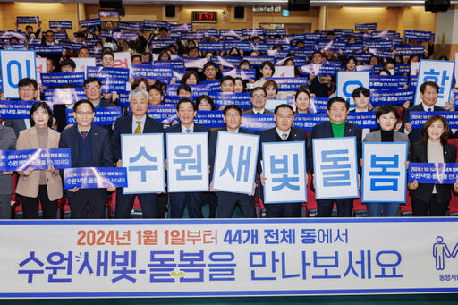지난 27일 이재준 수원특례시장(사진 왼쪽 네 번째)과 김기정 수원특례시의회 의장(사진 왼쪽 다섯 번째) 등이 시청 대강당에서 ‘수원새빛돌봄 확대 운영’을 알리는 손팻말을 들고 기념촬영을 하고 있다. 수원특례시 제공