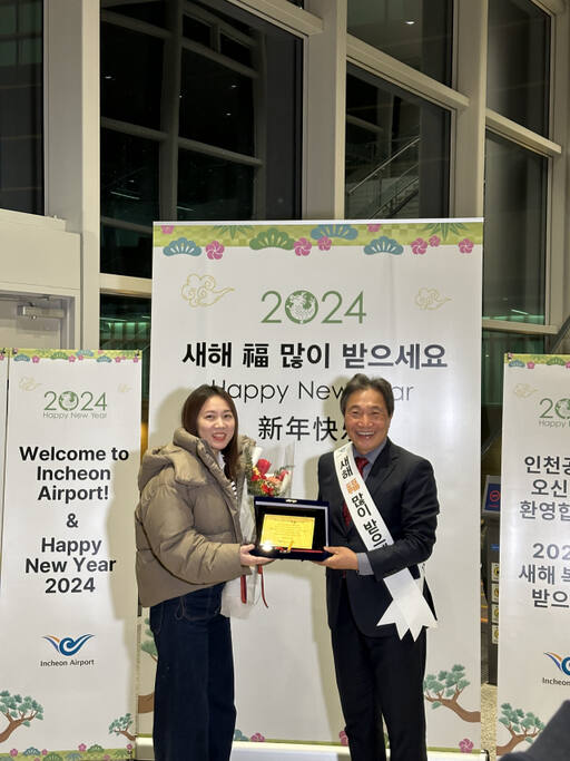 이학재 공항공사 사장이 대한항공 KE854편(베이징-인천)을 통해 인천공항에 도착한 새해 첫 여객 중국 국적의 쫑위에(Zong-yue)씨에게 황금 기념패와 대한항공 왕복 항공권, 그랜드하얏트 인천 호텔 숙박권 등의 선물을 증정하고 있다. 공항공사 제공
