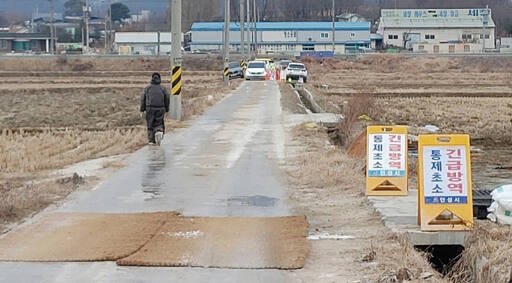고병원성 조류인플루엔자(AI) 확산방지를 위해 긴급방역 통제초소를 운영하며 도로에 방역포를 깔아놓았다.다. 경기도 제공