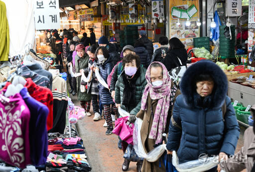 17일 오후 수원특례시 팔달구 못골종합시장에서 열린 '제11회 가래떡 나눔 행사'에서 시민들이 2백여미터의 가래떡을 뽑아 시장을 걸으며 새해 건강과 행운을 기원하고 있다. 윤원규기자