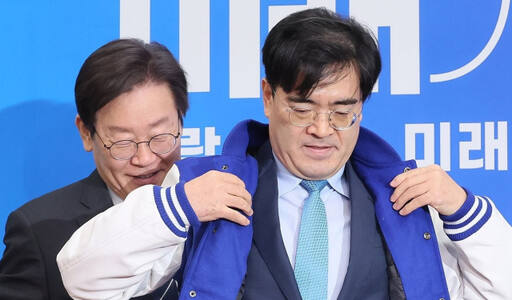 더불어민주당 이재명 대표가 22일 국회에서 열린 인재 영입식에서 공영운 전 현대자동차 사장에게 당 점퍼를 입혀주고 있다. 연합뉴스