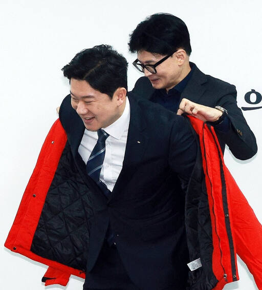 국민의힘 한동훈 비상대책위원장이 5일 '사격황제' 진종오 대한체육회 이사에게 당 점퍼를 입혀주고 있다. 연합뉴스