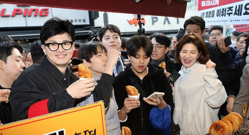 국민의힘 한동훈 비상대책위원장이 설 명절을 앞둔 2일 오후 경기도 구리시 구리전통시장을 방문해 호떡을 구입한 뒤 상인과 대화하고 있다. 연합뉴스