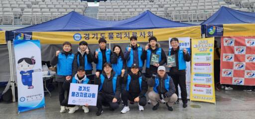 지난 25일 수원종합운동장에서 열린 ‘2024 경기수원국제하프마라톤’에서 경기도물리치료사회 회원들이 스포츠 테이핑 봉사를 한 뒤 기념촬영을 하고 있다. 경기도물리치료사회 제공