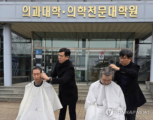 5일 강원 춘천시 강원대학교 의과대학 앞에서 의대 교수들이 대학 측의 증원 방침에 반발하며 삭발하고 있다. 연합뉴스