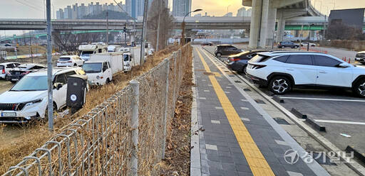 용인특례시 기흥구 신갈IC공영주차장 뒤편 단선 도로 양옆으로 차량들이 세워져 있지만 인근 신갈IC공영주차장은 한산한 모습이어서 대조를 이루고 있다. 송상호기자
