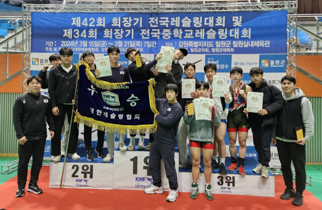 제42회 회장기 전국레슬링대회에서 남자 고등부 자유형에서 종합우승 2연패를 달성한 수원 곡정고 선수들이 우승기를 펼쳐들고 기념촬영을 하고 있다.곡정고 제공