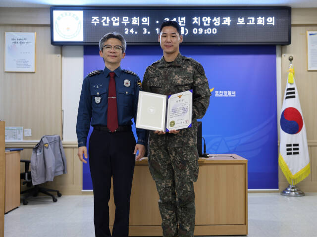 이병우 포천서장이 18일 음주운전 뺑소니범을 검거하는데 기여한 수도기계화보병사단 강한솔 상사에게 경찰서장 표창장을 전달하고 기념사진을 찍고 있다. 포천경찰서 제공