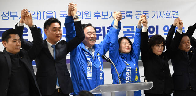 더불어민주당 의정부갑 박지혜 후보와 의정부을 이재강 후보가 21일 ‘새로운 의정부를 위한 공동의 약속’을 발표한 뒤 도·시의원들과 두손을 맞잡고 총선 승리를 다짐하고 있다. 조주현 기자