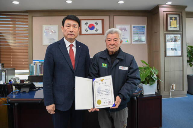 (오른쪽)박재근씨가 송병억 수도권매립지관리공사 사장으로부터 감사장을 전달받고 기념사진을 찍고 있다. 수도권매립지관리공사 제공