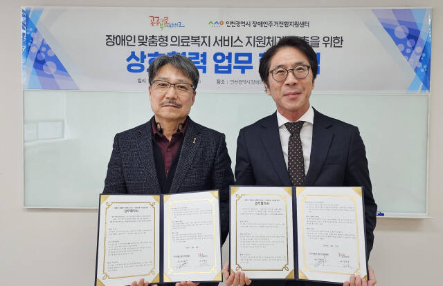 22일 정재원 인천시장애인주거전환지원센터장과 김성국 공공의료복지네트워크 대표가 업무협약을 한 뒤 기념촬영 하고 있다. 인천사서원 제공