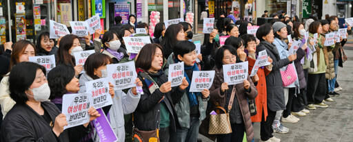 (사)수원여성의전화 등 관내 여성단체 회원들이 12일 오후 수원역 문화광장에서 성인엑스포 ‘2024 K-XF 더 패션’ 개최를 규탄하는 기자회견을 열고 구호를 외치고 있다. 경기일보