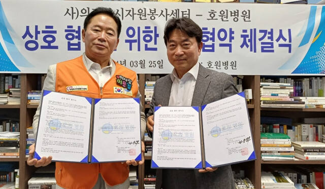 이용걸 의정부시자원봉사센터 이사장과 박향진 윤영의료재단 호원병원 이사장이 자원봉사 활성화를 위한 업무협약을 체결한 뒤 기념촬영하고 있다. 의정부시자원봉사센터 제공