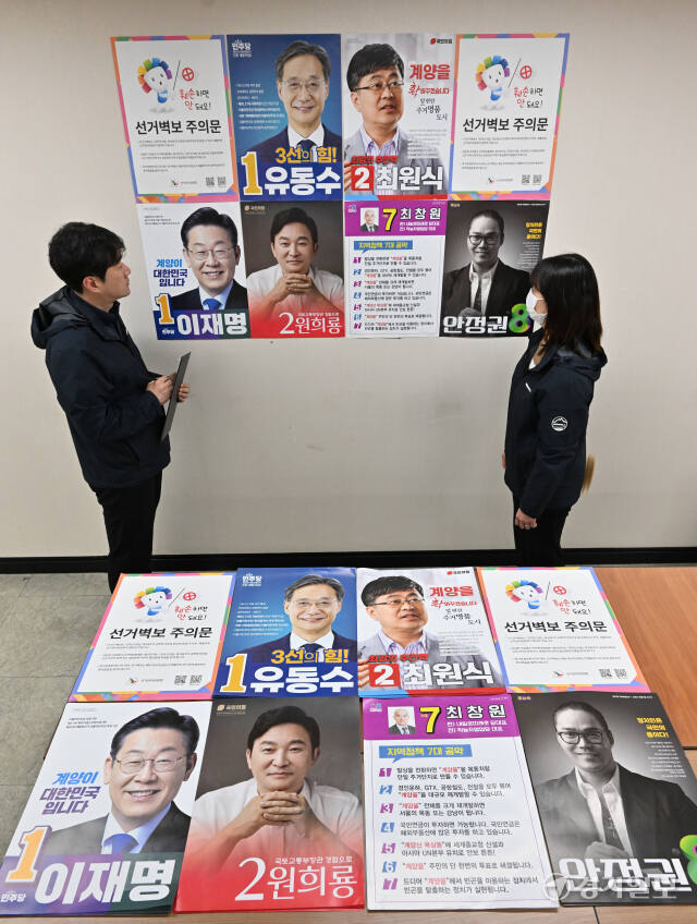 제22대 국회의원선거 공식 선거운동을 앞둔 27일 인천 계양구청에서 선거관리위원회 관계자들이 계양갑·을 후보들의 선거벽보를 확인하고 있다. 조병석기자