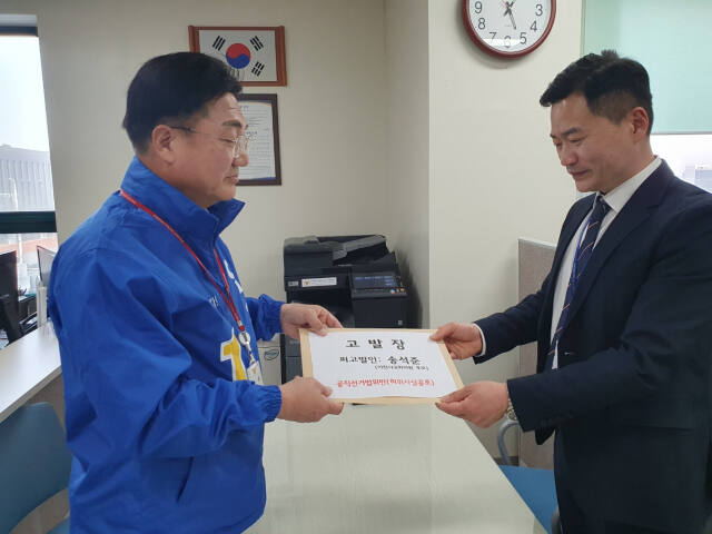 민주 엄태준 후보(왼쪽)가 이천경찰서 직원에게 국힘 송석준 후보를 공직선거법 위반 혐의로 고발장을 제출하고 있다. 엄태준 후보 캠프 제공