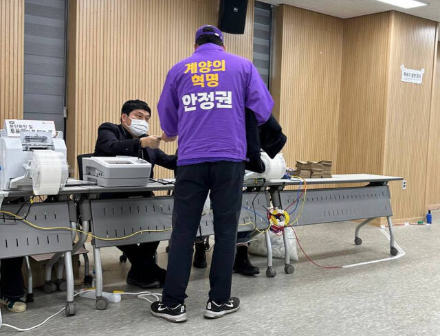 6일 선관위에 이의를 제기하기 위해 계양2동 사전투표소의 한 참관인이 증거로 촬영한 사진. 한 남성이 특정 후보의 이름이 적힌 상의를 입은 채 투표용지를 받고 있다. 독자 제공