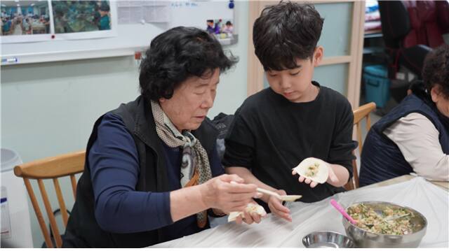 최근 서구 다함께돌봄센터 2호점 아동들과 경로당 어르신이 함께 만두 빚기 프로그램을 하고 있다. 인천사서원 제공