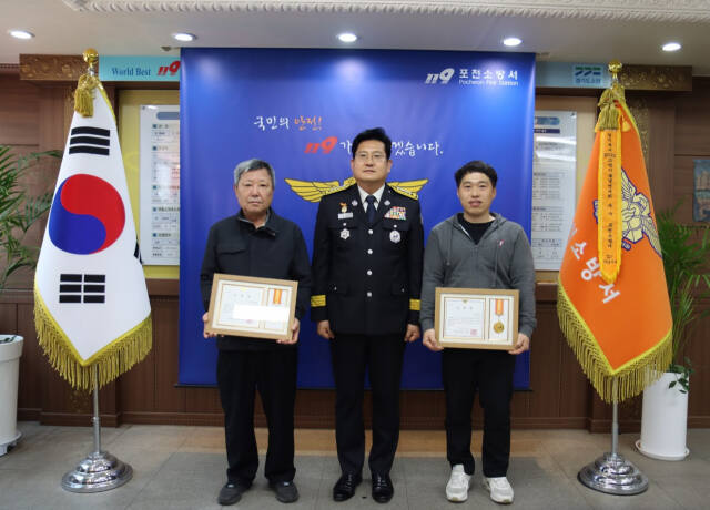 포천소방서는 9일 신속한 초기대응으로 아파트 화재 피해를 막은 김성민 소방안전관리자(오른쪽)와 경비원 조규호씨에게 소방서장 표창을 수여했다. 포천소방서 제공