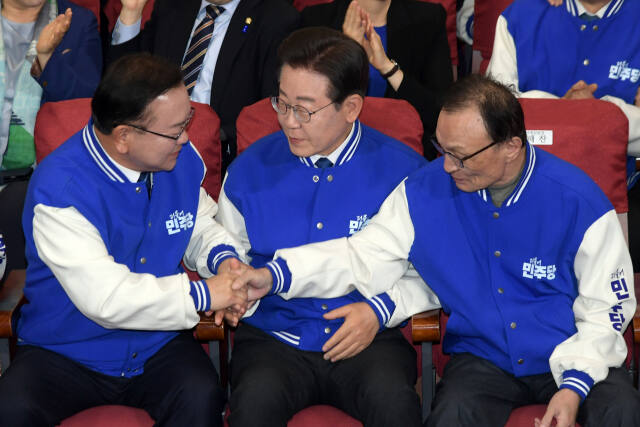 더불어민주당 이재명 대표, 이해찬·김부겸 상임공동선거대책위원장이 10일 오후 국회 의원회관에 마련된총 총선 개표상황실에서 방송 3사의 출구조사 결과를 지켜본 뒤 손을 잡고 있다. 연합뉴스