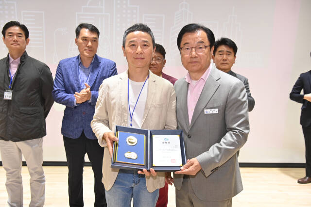 심폐소생술로 어르신의 생명을 구한 하남시 환경미화원 신창흔씨(왼쪽)가 이현재 하남시장에게 표창을 수여받고 있다. 하남시 제공