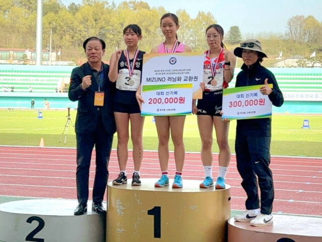 제53회 춘계 전국중·고육상대회 여중부 3천m 경보서 대회신기록을 세우며 2연패를 달성한 권서린(가운데)이 김유미 코치(오른쪽)와 시상대에서 신기록 포상금 보드를 들고 기념촬영을 하고 있다.경기도육상연맹 제공
