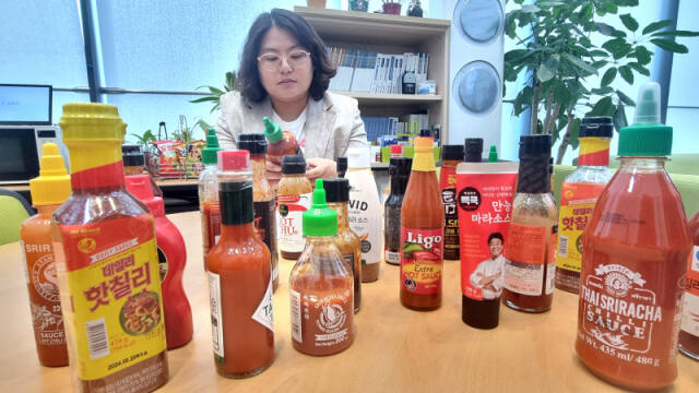 한국소비자연맹이 18일 오전 정부세종청사 공정거래위원회 브리핑실에서 ‘매운맛 소스’ 20개 제품을 비교한 실험 결과를 발표했다. 사진은 직원이 제품을 살펴보는 모습 /연합뉴스