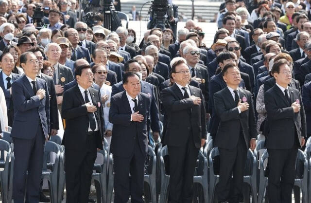 한덕수 국무총리와 더불어민주당 이재명 대표 등이 19일 오전 서울 강북구 국립 4·19민주묘지에서 열린 제64주년 4·19 혁명 기념식에 참석해 국기에 경례하고 있다. 연합뉴스