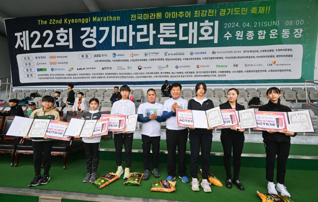 제22회 경기마라톤대회 꿈나무 장학금 시상식 후 경기일보 신항철 회장(오른쪽 4번쨰)과 김진원 경기도육상연맹 회장(5번째)이 장학금 수혜자들과 기념촬영을 하고 있다.윤원규기자