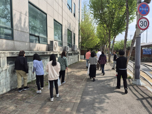 구리 시민들이 폐타이어와 깡통, 쓰레기통, 화분받침 등을 정리하고 있다. 구리시 제공