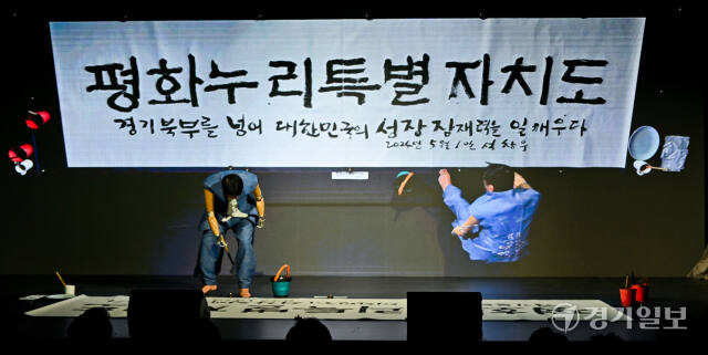 경기북부특별자치도 새 이름 대국민 보고회가 열린 1일 오후 경기도북부청사 평화누리홀에서 석창우 화백이 공모전을 통해 선정된 새 이름 '평화누리특별자치도'를 공개하는 서예 퍼포먼스를 하고 있다. 윤원규기자