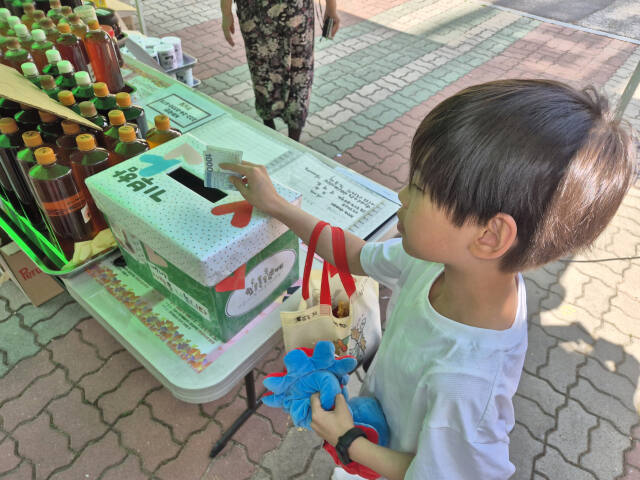 한 학생이 안양 다함께돌봄센터에서 열린 바자회에서 물건을 판 돈을 기부하고 있다. 윤현서기자