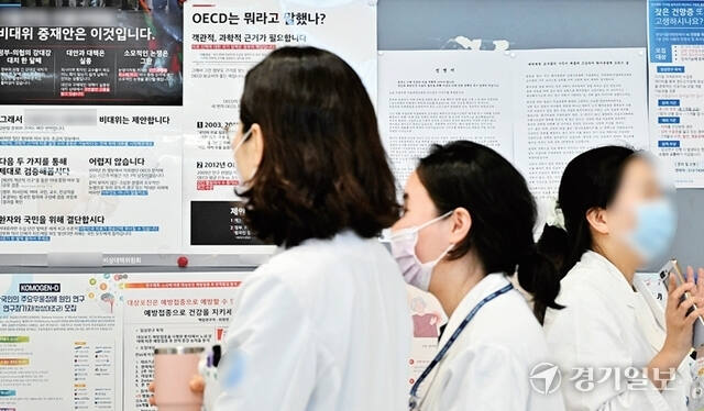 전국의과대학교수협의회(전의교협)가 4일 정부를 향해 의대 정원 증원에 관한 근거 자료와 회의록을 명백히 공개하라고 촉구했다. 사진은 지난달 경기도내 한 대학병원에 부착된 의대 증원 관련 성명서 및 포스터 앞으로 의료진이 지나가고 있는 모습. 홍기웅기자