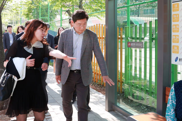지난 3일 오후 청곡초 승하차공간 현장에서 이상일 용인특례시장이 기흥구 영덕2동 주민간담회에서 나온 안건과 관련된 온열의자 설치 여부를 검토하고 있다. 용인특례시 제공