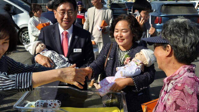 전진선 양평군수와 전은경 곡수초등학교 교장이 아기 인형을 안고 ‘아이들 키우기 좋은 마을’ 체험을 하고 있다. 곡수초등학교 제공