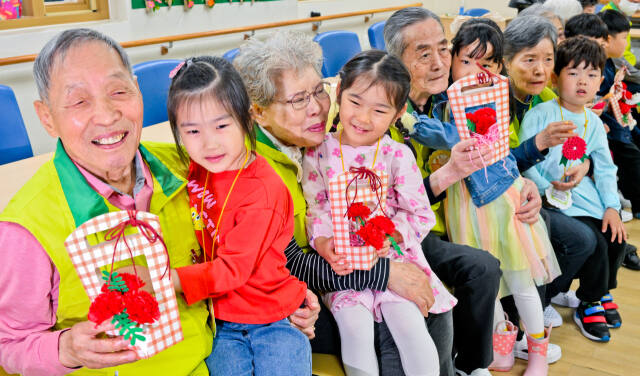 어버이날을 하루 앞둔 7일 오전 수원특례시 팔달구 팔달노인복지관에서 관내 어린이집 아이들이 어르신들에게 카네이션을 달아드린 뒤 포옹하고 있다. 윤원규기자