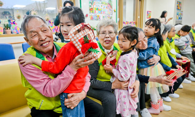 어버이날을 하루 앞둔 7일 오전 수원특례시 팔달구 팔달노인복지관에서 관내 어린이집 아이들이 어르신들에게 카네이션을 달아드린 뒤 포옹하고 있다. 윤원규기자
